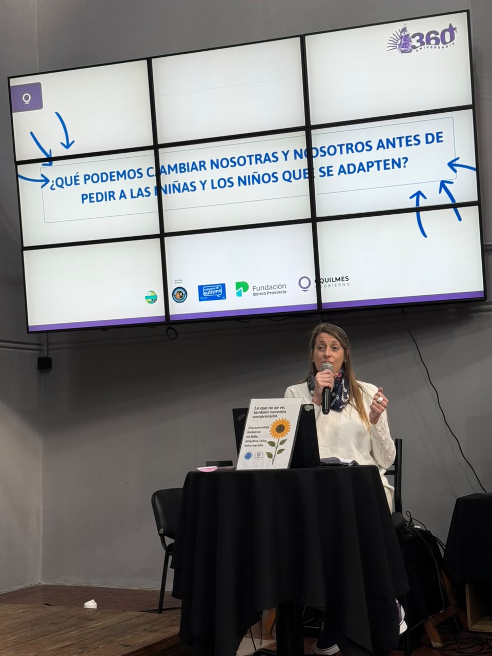 Pamela Mateos exponiendo con micrófono en una jornada sobre autismo